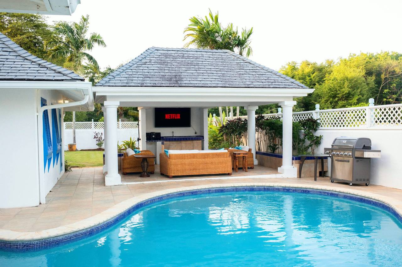 Pool and gazebo with outdoor TV and BBQ grill at The Heart Villa in Canaan, Tobago, set up for a holiday gathering